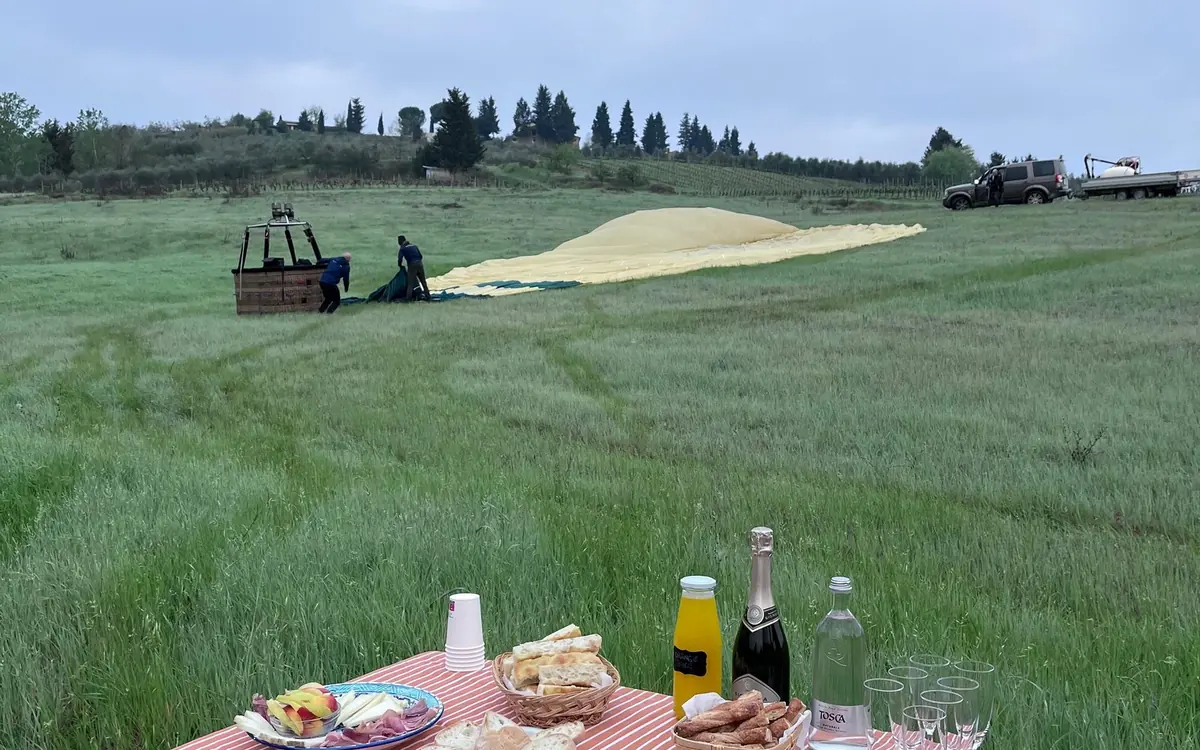 A breakfast table set in a Tuscan field after a balloon landing